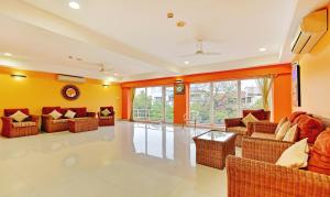 钦奈Treebo Trend Vapr Guindy Ekkatuthangal的客厅设有橙色墙壁和沙发