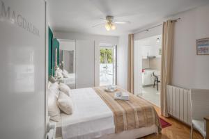 波雷奇卡塔娜公寓别墅酒店的一间白色卧室,配有床和一间浴室