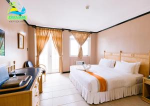 麦克坦维斯塔海滩度假及乡村俱乐部酒店的配有一张床和一张书桌的酒店客房