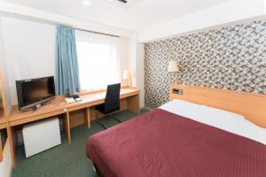 仓吉市方舟酒店21的酒店客房配有一张床和一张书桌及一台电视