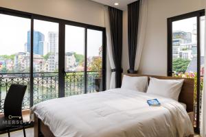 河内Mersey Central Hanoi Apart'Hotel的一间带大床的卧室和一个阳台