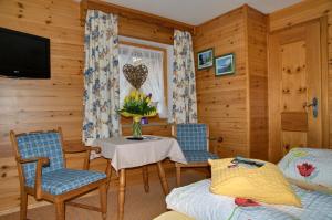 柯尼希斯湖畔舍瑙Landhaus Maltermoos的客厅配有桌椅和电视。