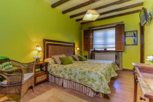 卡尔达斯·德·雷斯卡萨塞勒尼斯乡村民宿的一间卧室设有绿色的墙壁、一张床和椅子