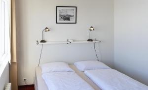 达尔维克达尔维克酒店的墙上有架子的房间,设有两张床