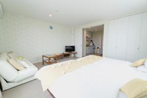 宫古岛Ecot 下里２的卧室配有白色的床和沙发