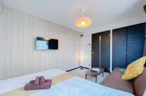 东京japan house sky tree的一间卧室配有一张床、一张沙发和一台电视