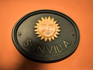 IllovoVilla Spa Holiday Resort的墙上有太阳标志的飞盘