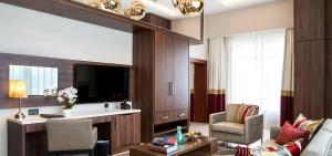 阿布贾Room in Lodge - The Envoy Hotel and Suites的客厅配有电视、沙发和椅子