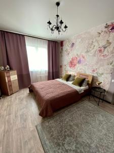 苏尔古特Уютная квартира на Ауре的一间卧室设有一张床和花卉墙