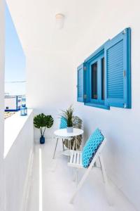 科蒂略Apartamentos Cotillo Surf的一间设有桌子和蓝色窗户的客房