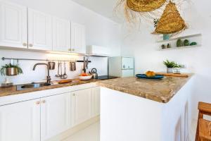科蒂略Apartamentos Cotillo Surf的厨房配有白色橱柜、水槽和柜台。