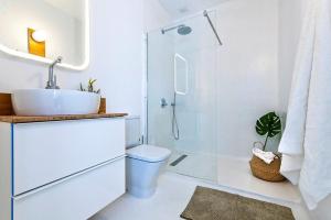 科蒂略Apartamentos Cotillo Surf的白色的浴室设有水槽和淋浴。