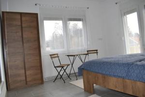 武科瓦尔Apartman WALKOW的一间卧室配有一张床、一张桌子和两把椅子
