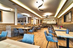 博登迈斯Camping Resort Bodenmais的餐厅设有木桌和蓝色椅子