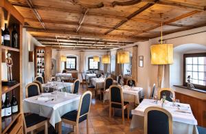 丘萨安斯茨弗特克劳斯酒店的一间带桌椅和葡萄酒瓶的餐厅