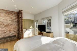 华盛顿Lofty DC Sanctuary的卧室配有白色的床和砖墙