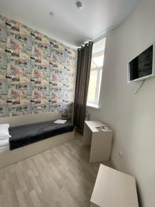 科斯特罗马Art-Hotel Centralnyi的一间设有床铺和挂有海报的墙壁的房间