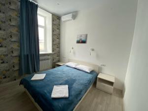科斯特罗马Art-Hotel Centralnyi的一间卧室设有蓝色的床和窗户。
