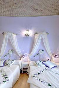 卢切拉罗莎斯特拉旅馆的紫色墙壁客房的两张床