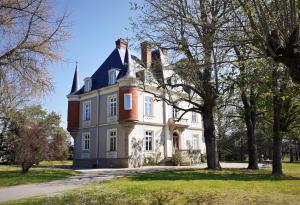 Sainte-Agathe-la-BouteresseDomaine du Perrier的前面有一棵树的大白色房子