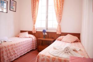 福尔内利斯Homenfun Menorca Playa de Fornells II的一间卧室设有两张床和窗户。