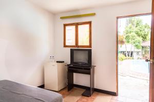 麦德林Ayenda 1257 Premium Real的一间卧室配有电视和小冰箱