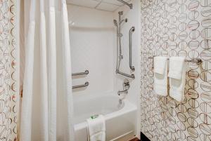 海茨敦温莎东部假日酒店的浴室配有白色的淋浴帘和浴缸。