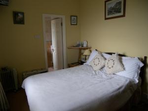 Murrisk阿基尔景观住宿加早餐旅馆的一间卧室配有带白色床单和枕头的床。