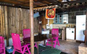 卡塔赫纳Chalet de Lujo en La Manga的厨房配有木桌和粉红色的椅子