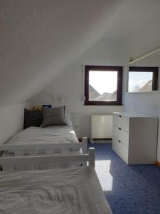 腓特烈斯科格Ferienhaus "Hygge Friedrichskoog-Spitze"的一间卧室配有一张床、一个梳妆台和一扇窗户。