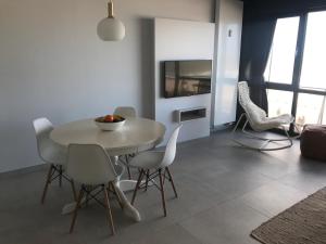 奥斯坦德Luxury Seaview Apartment with free private garage的一间配备有白色桌椅的用餐室