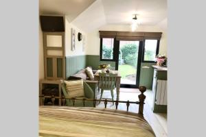 朗梅尔福德Melford Allotment Shed-Vintage Lodge Suffolk的一间卧室配有一张床、一张桌子和一张沙发