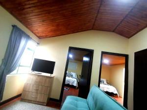 瓜斯卡Naturaleza Muisca的带沙发、电视和镜子的客厅