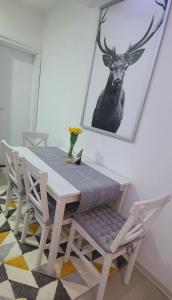 新瓦罗什Apartman Iva的一张桌子和椅子,墙上挂着一幅鹿的照片