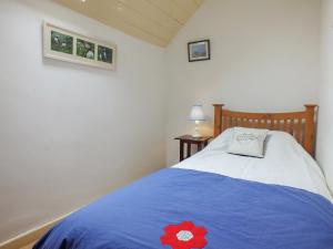 GoodwickTy Gwyn的一间卧室配有一张蓝色的床,上面有红花