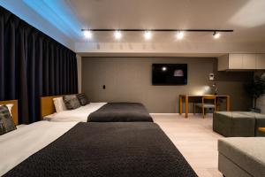 大阪STAY IN YEBISU的一间酒店客房,设有两张床和电视