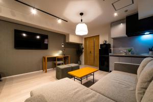 大阪STAY IN YEBISU的客厅配有沙发和桌子
