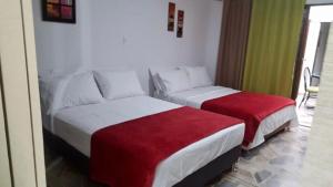 卡利Moderno apartasuite con aire acondicionado的酒店客房,配有两张带红色床单的床