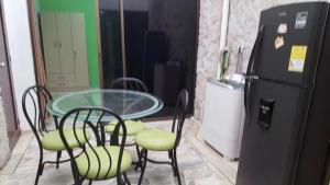 卡利Moderno apartasuite con aire acondicionado的桌椅、玻璃桌和冰箱