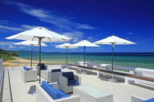 石垣岛石垣岛七色酒店的海滩上带椅子和遮阳伞的庭院