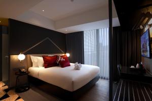 三宝垄Awann Sewu Boutique Hotel and Suite Semarang的一间卧室配有一张带红色枕头的大床