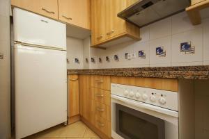 迈阿密普拉特亚Rentalmar Gavina d'Or Apartamentos的厨房配有白色冰箱和炉灶。