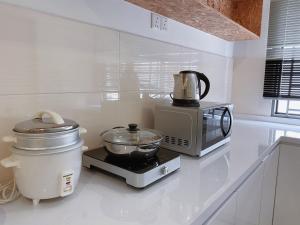 迪沙鲁Desaru KTV Natural wood style by Joyfully 31A7的厨房配有微波炉和台面上的搅拌机
