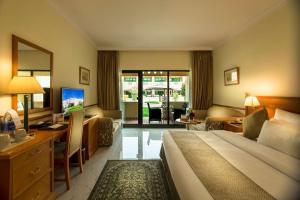 尼兹瓦金色郁金香尼兹瓦酒店的配有一张床和一张书桌的酒店客房