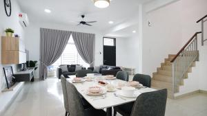 迪沙鲁Desaru Home Feel Theme by Joyfully 13M1的用餐室以及带桌椅的起居室。