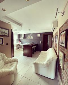 锡萨克Apartment Klet的一间带白色沙发的客厅和一间厨房
