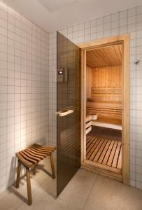 格丁尼亚安塔尔斯酒店的一个带长凳和玻璃门的桑拿浴室
