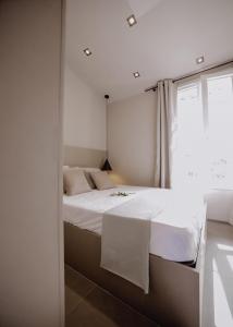 圣特罗佩Le Beach的卧室配有白色的床和窗户。