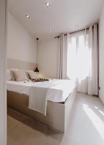圣特罗佩Le Beach的白色的卧室设有一张大床和一个窗户