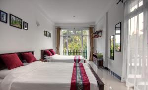 康提De Paris à Kandy的一间卧室设有两张床和窗户。